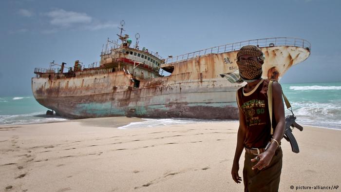 O pirata somali Abdi Ali ao pé dum barco de pesca do Taiwan (dw.de)