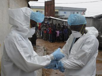 Agentes sanitários preparam-se para analisar o cadáver de uma vítima de ébola, Monrovia, 17 de Agosto de 2014. (REUTERS)