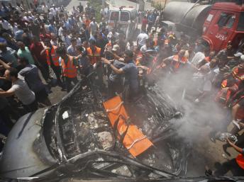 Palestinos cercam um carro atingido em Gaza por um bombardeio aéreo de Israel neste domingo, 24 de agosto. (Foto: Reuters)