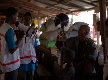 UNICEF e parceiros visitar um mercado lotado em Conacri, na Guiné, para explicar como podem se proteger e suas famílias do Ebola. 22/08/2014 (UNICEF Guiné)