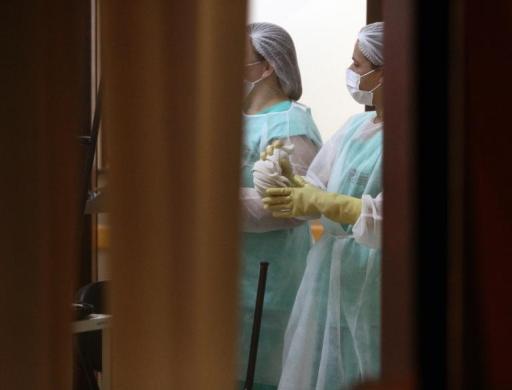 Enfermeiras aguardam no aeroporto de Cascavel, Paraná, a chegada de um homem da Guiné com suspeita de Ebola, transferido para o Rio de Janeiro. (Foto de FABIO CONTERNO/AFP)